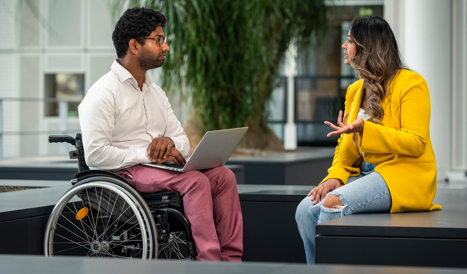 Man in rolstoel in gesprek met een vrouw